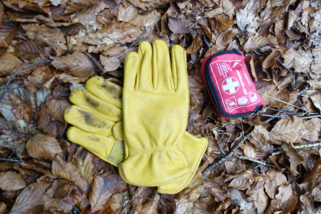 Bild 1: Sollte immer dabei sein, wenn man im Wald arbeitet! Erstehilfe Set und Handschuhe.